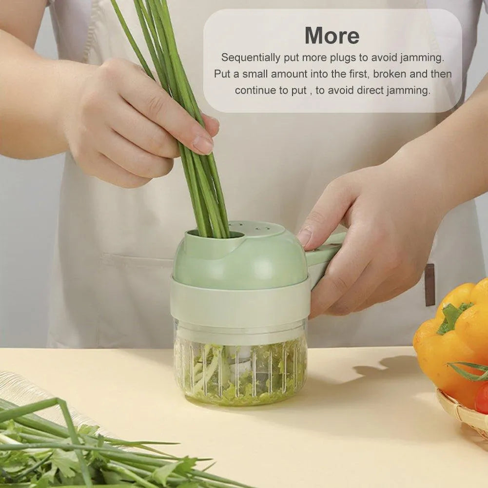 Hand holding a 4-in-1 handheld electric vegetable cutter processing green onions on a kitchen counter.